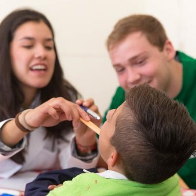 Interns examine a boy during a health screening outreach on one of our medical placements abroad.